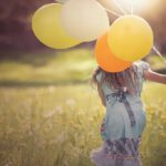 Mädchen rennt mit Luftballons