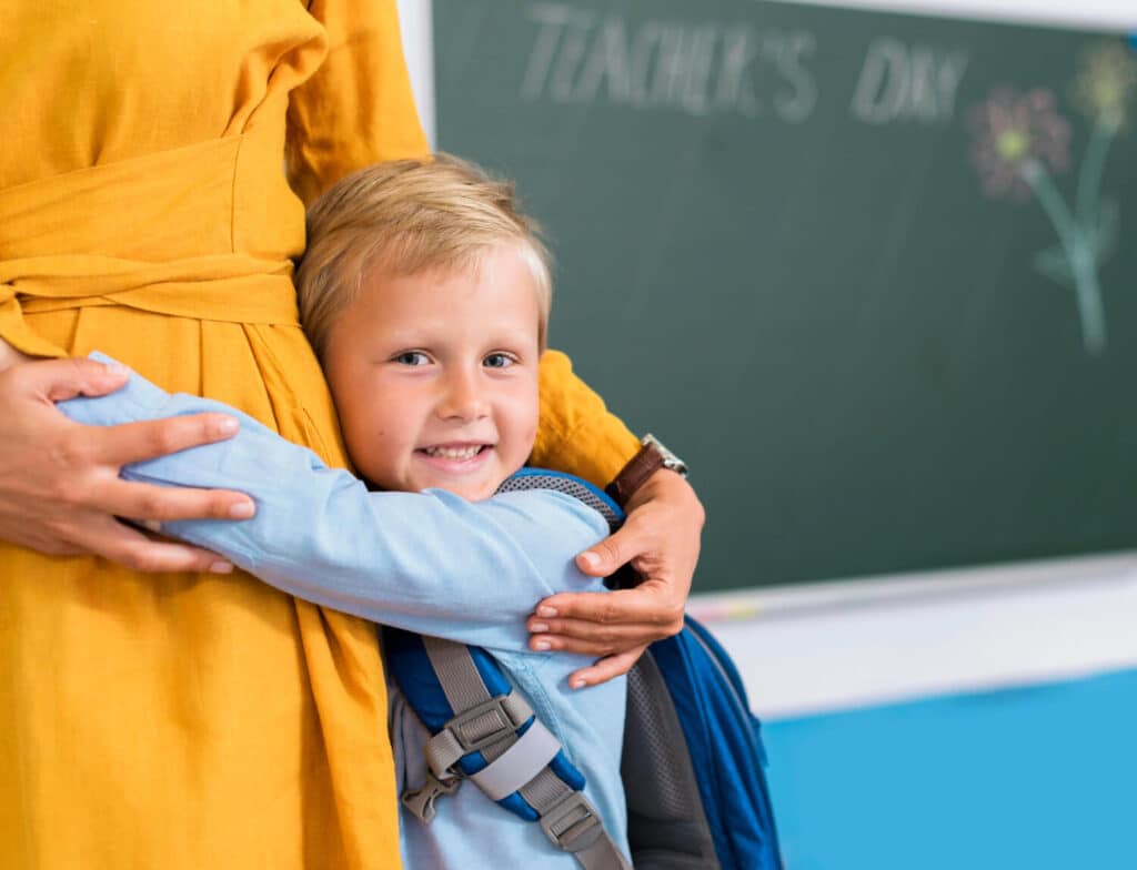 Schulstart mit Herz - Junge klammert zur Einschulung an Mama
