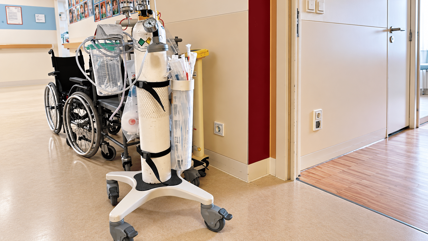 Mobiler Sauerstoffwagen mit Sauerstoffflaschen und Notfallzubehör vor dem Patientenzimmer